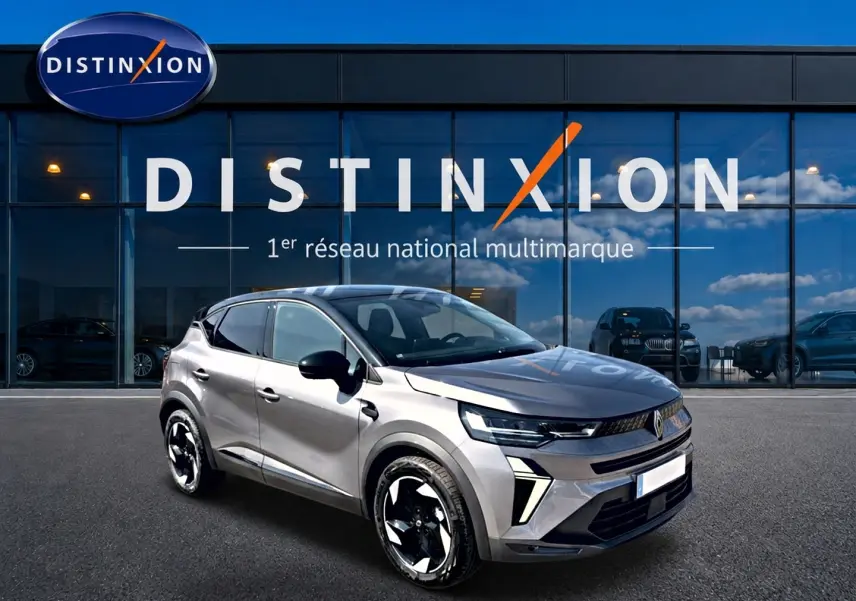 Renault Captur 1.2 TCe 115 Techno gris Cassiope toit noir, vue 3/4 avant avec jantes noires et blanches, devant showroom Distinxion.