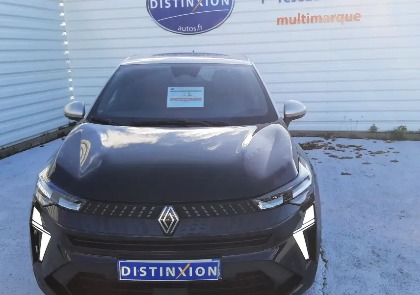 Vue frontale du Renault Captur 1.3 TCE 140 MHEV TECHNO 2024 en noir métal avec toit gris, feux LED allumés.