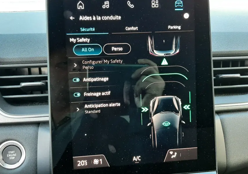 Écran tactile central du Renault Captur 2024 affichant les aides à la conduite dans un intérieur noir.