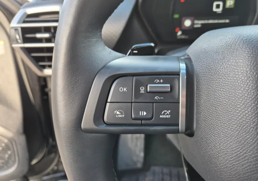 Gros plan sur les commandes du volant cuir du Citroën C5 X noir 2024, avec régulateur et assistant de conduite.