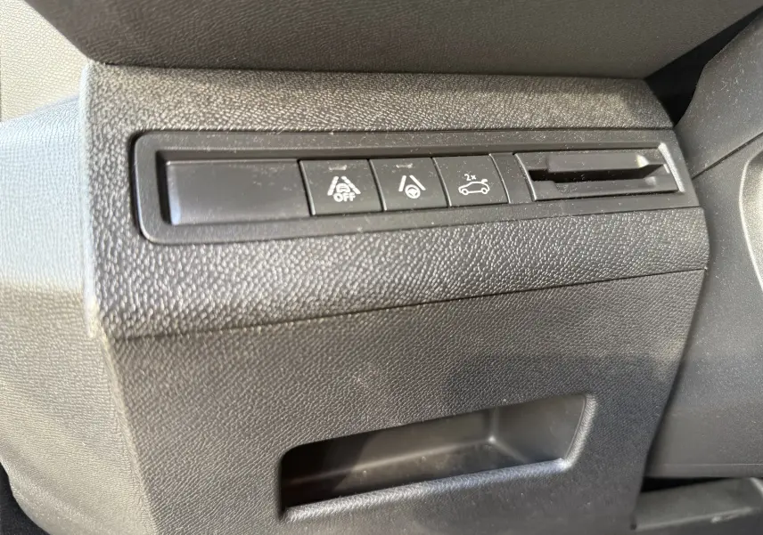 Gros plan sur les boutons de commande noirs du tableau de bord côté conducteur du Peugeot 3008 gris 2022.