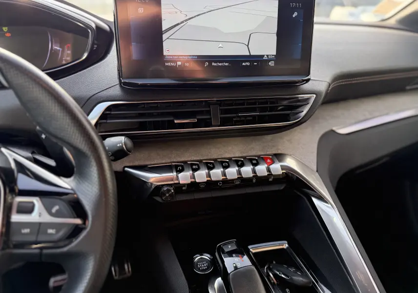 Vue intérieure du tableau de bord et console centrale du Peugeot 3008 gris, avec écran tactile et commandes piano visibles.