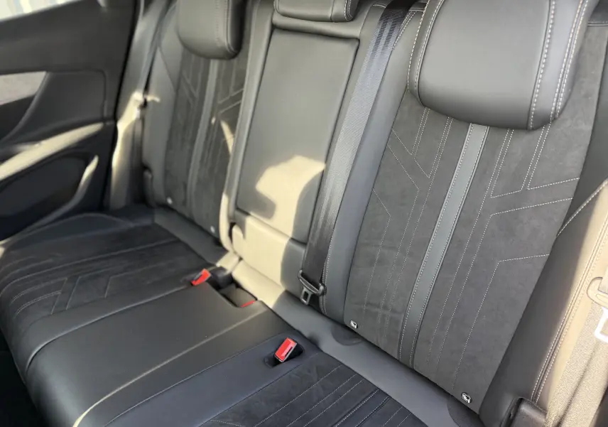 Vue intérieure sur la banquette arrière en cuir noir avec surpiqûres blanches du Peugeot 3008 gris de 2022.