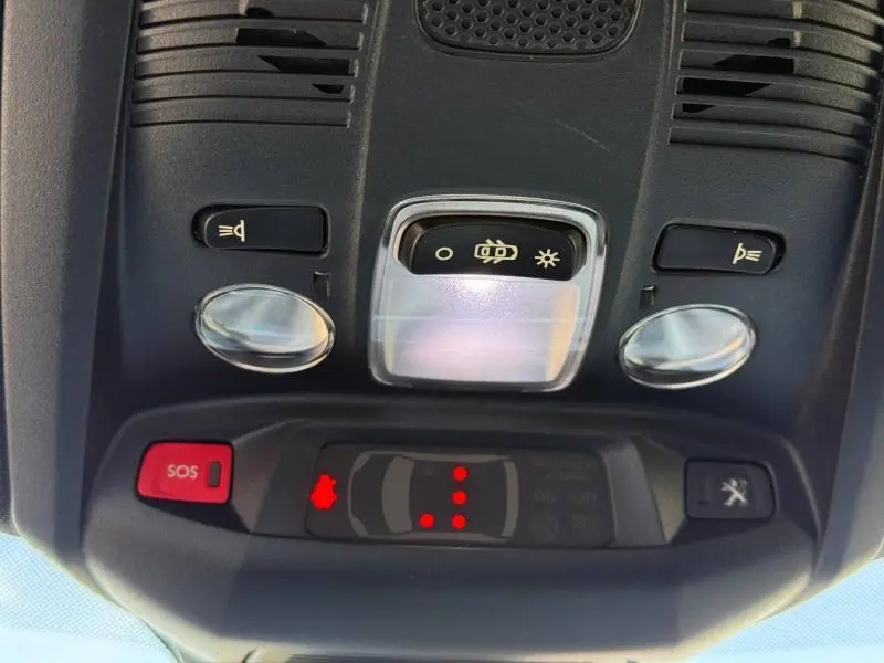 Vue rapprochée du plafonnier intérieur du Peugeot 3008 2024, avec boutons de lumière et alerte SOS visibles.