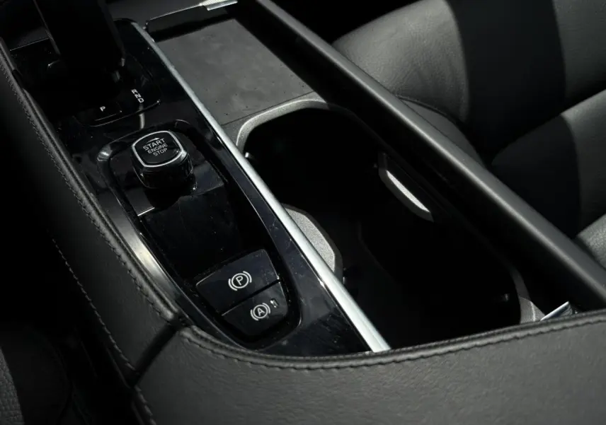 Gros plan sur la console centrale noire avec bouton Start/Stop et frein de parking du Volvo XC90 T8 gris Dusk.