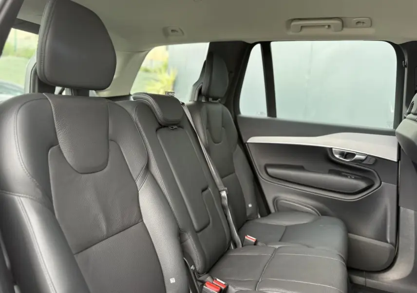 Vue intérieure côté droit des sièges arrière en cuir noir du Volvo XC90 T8 AWD 2024, avec appuie-têtes et ceintures visibles.