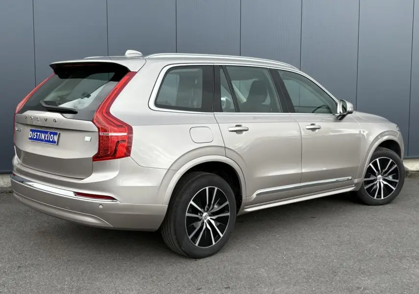 Vue 3/4 arrière droite du Volvo XC90 T8 hybride gris Dusk avec jantes alliage noires et chrome autour des vitres.