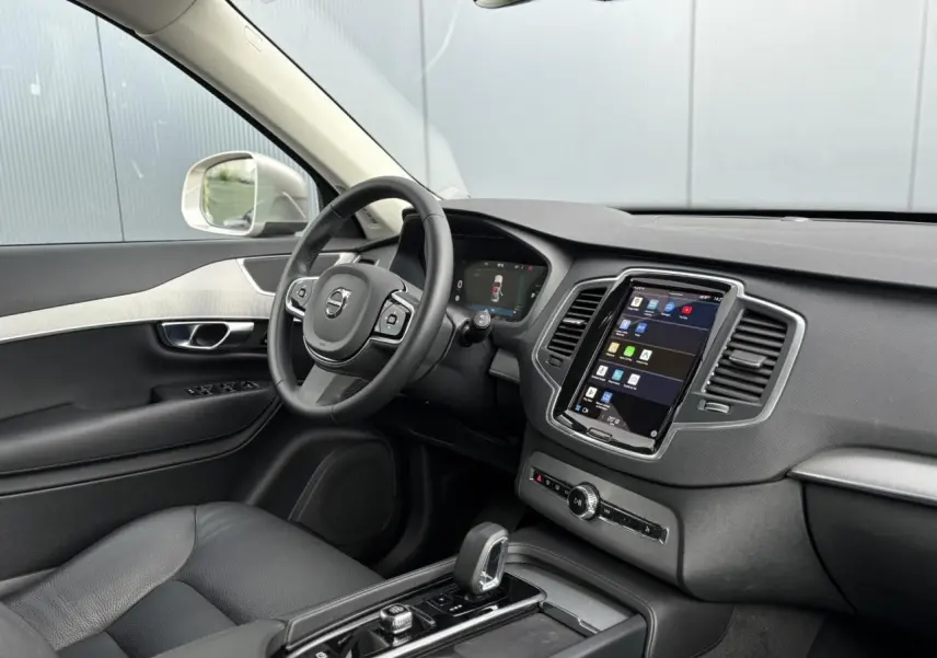 Vue intérieure côté conducteur du Volvo XC90 gris Dusk 2024, avec tableau de bord digital et écran tactile central.