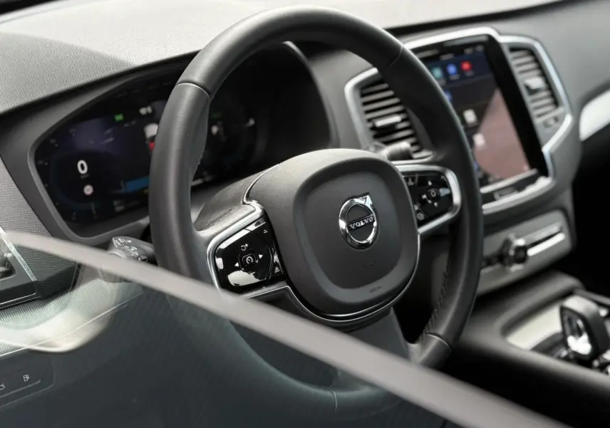 Vue rapprochée du volant noir et du tableau de bord digital du Volvo XC90 2024, intérieur moderne et épuré.