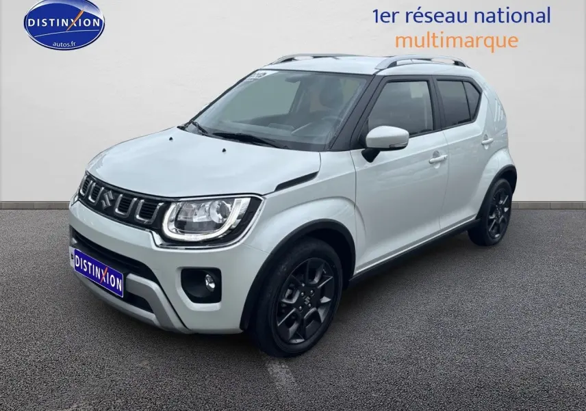 Suzuki Ignis blanc perle vue 3/4 avant droit avec jantes noires et barres de toit visibles.