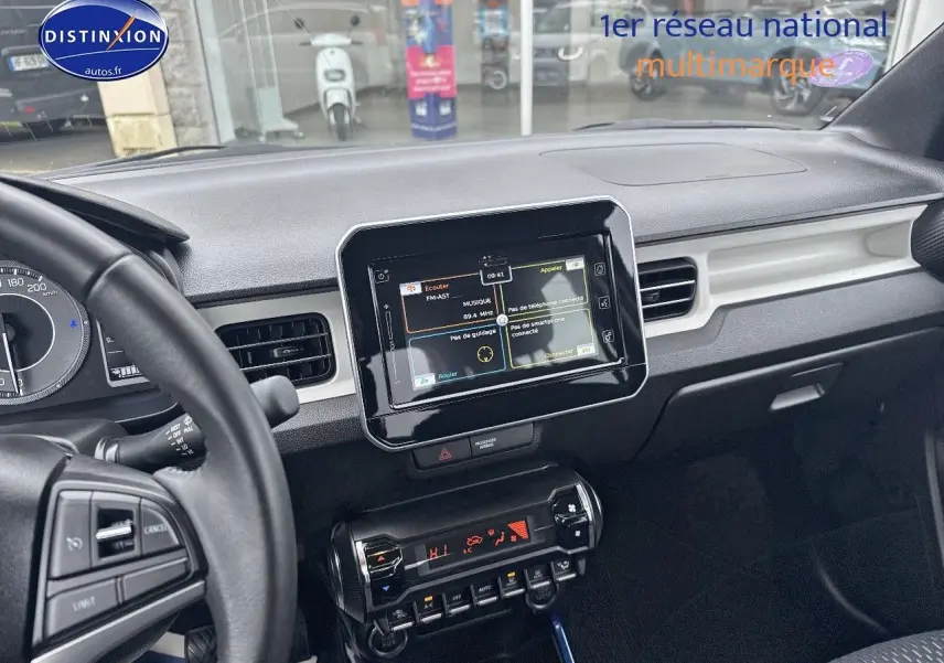 Vue intérieure du tableau de bord de la Suzuki Ignis 2023, écran tactile central et volant multifonction noir.