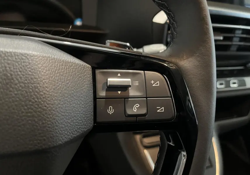 Gros plan sur les commandes au volant en cuir noir du Peugeot Expert Fourgon blanc, mettant en valeur les boutons multifonctions.