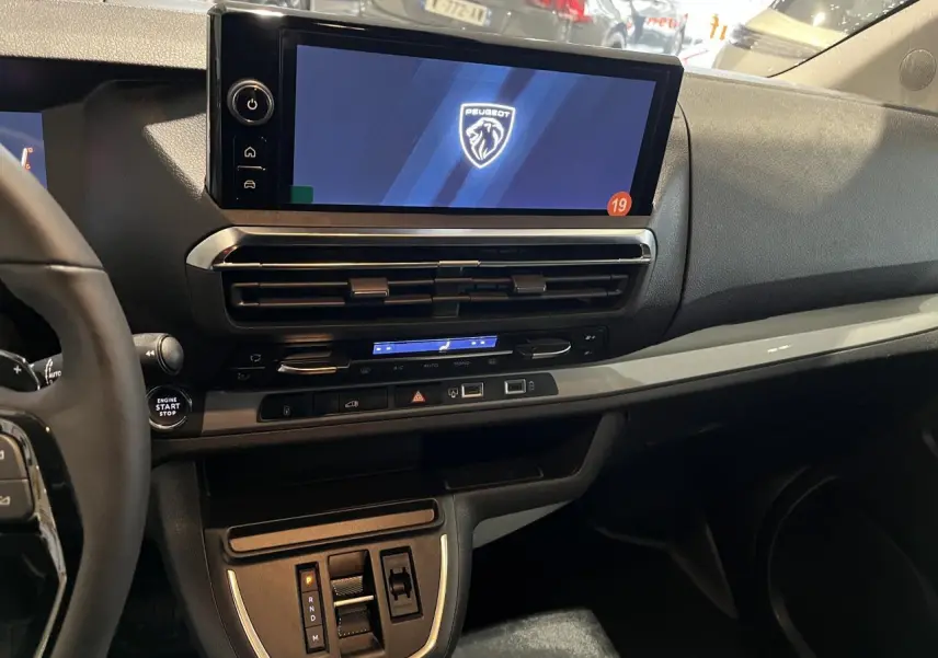 Vue intérieure rapprochée du tableau de bord du Peugeot Expert Fourgon blanc 2024 avec écran tactile 10 pouces et volant cuir.
