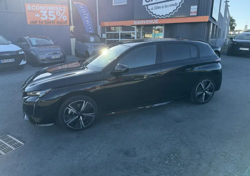 Peugeot 308 2024 noire vue de profil côté gauche, avec jantes alliage et vitres teintées.