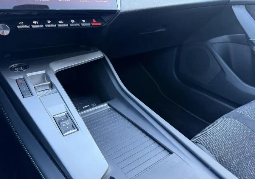 Gros plan sur la console centrale grise et noire de la Peugeot 308 2024 avec commandes Drive Mode et bouton start.