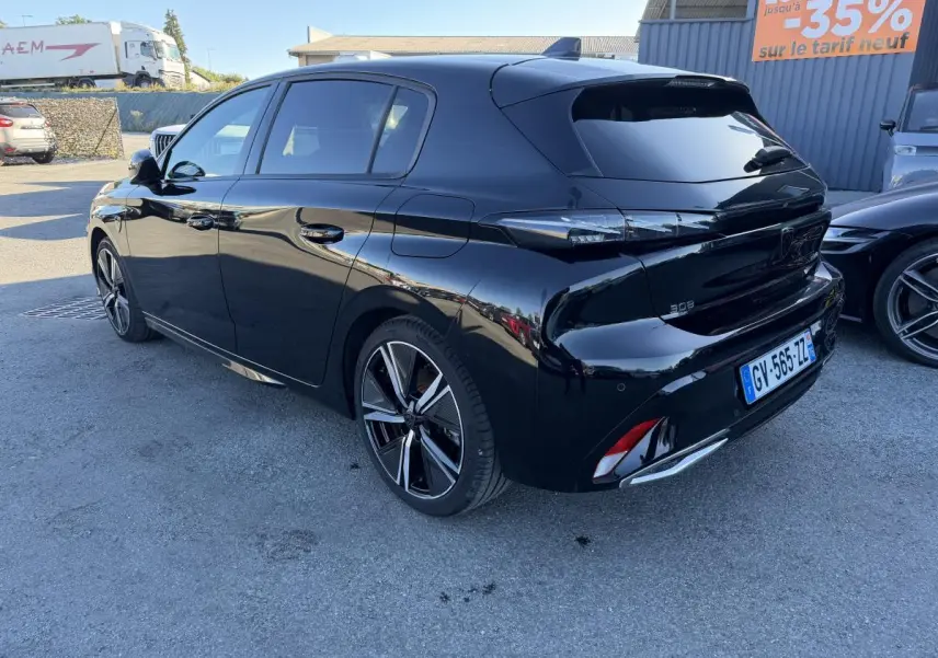 Peugeot 308 noire vue en 3/4 arrière droit, avec jantes alliage 18'' et feux arrière à signature lumineuse dynamique.