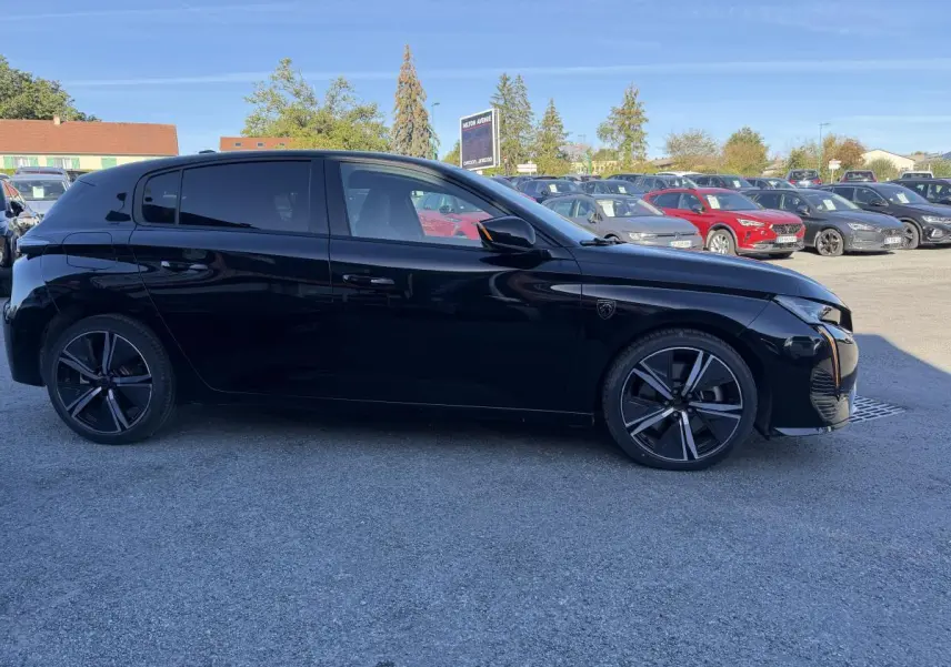 Peugeot 308 2024 noire vue de profil côté gauche, avec jantes alliage et vitres surteintées.