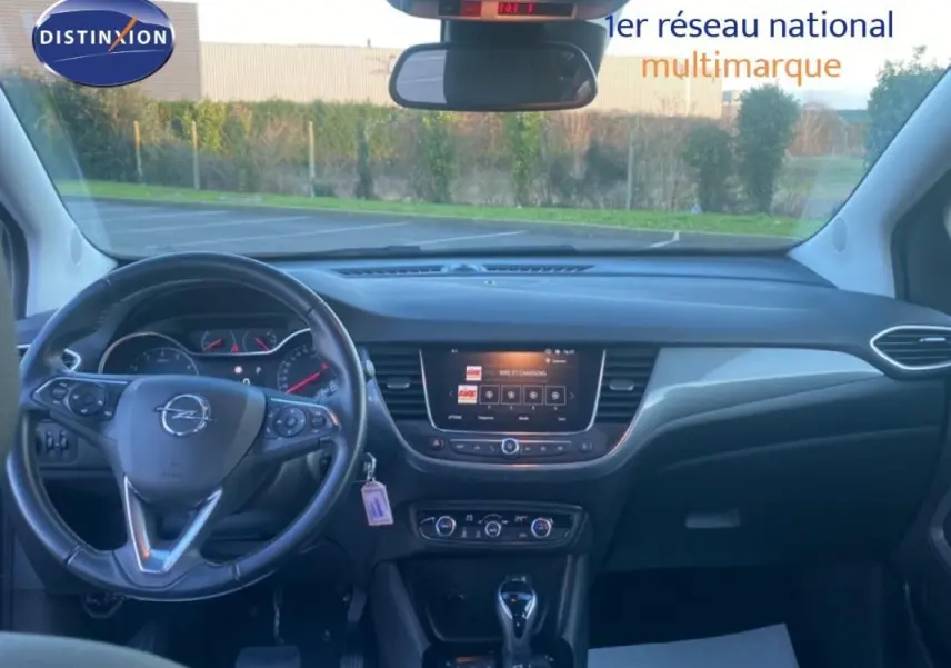 Vue intérieure frontale du tableau de bord et volant cuir noir de l'Opel Crossland 2022 avec écran tactile central et commandes multifonctions.