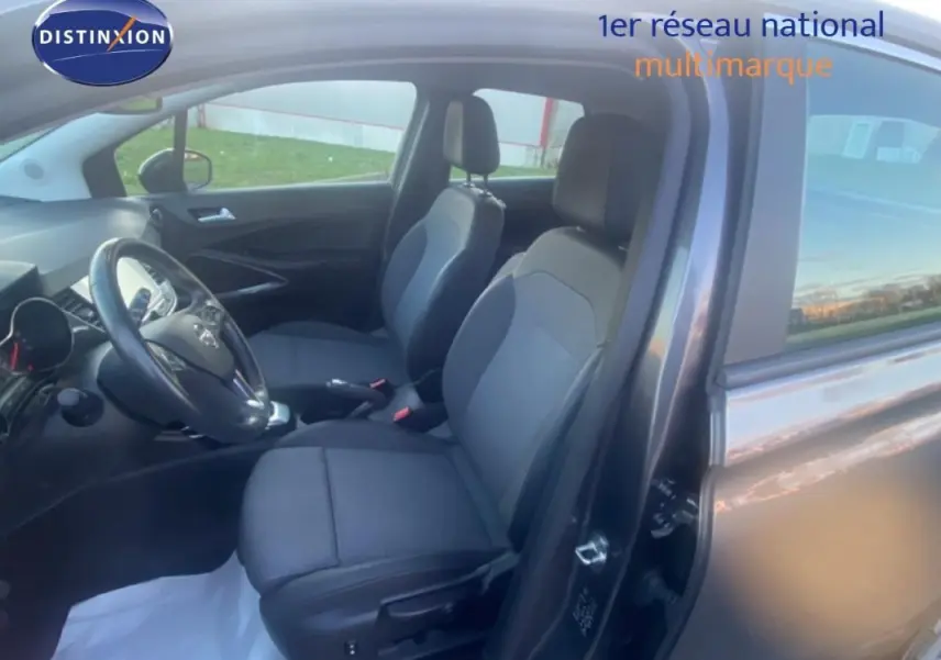 Vue intérieure côté conducteur de l’Opel Crossland gris foncé, montrant les sièges avant et le volant multifonctions en cuir.