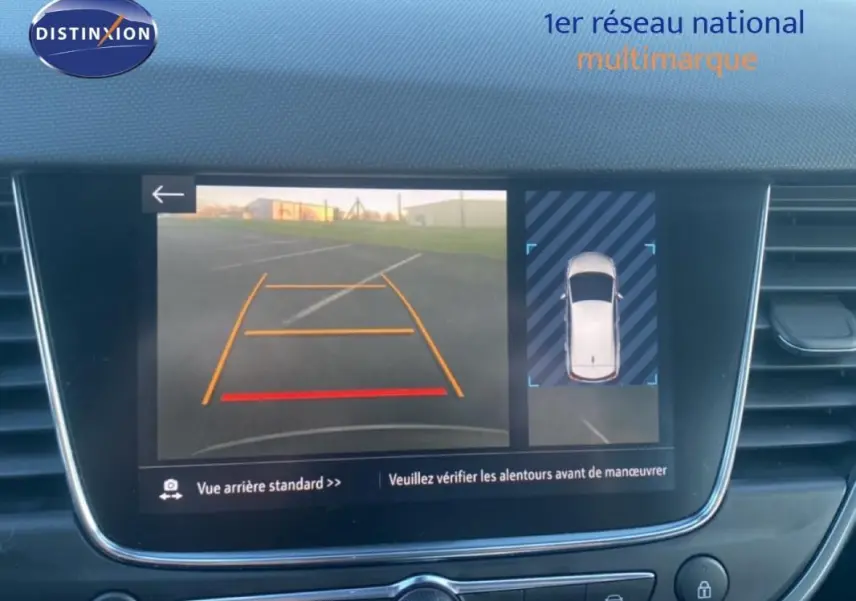 Écran intérieur affichant la caméra de recul et vue 360° d’une Opel Crossland gris foncé, tableau de bord moderne.