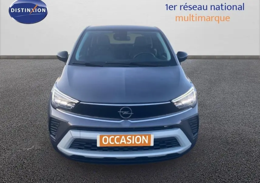 Vue avant d'un Opel Crossland gris foncé 2022 avec phares allumés et calandre noire distinctive.
