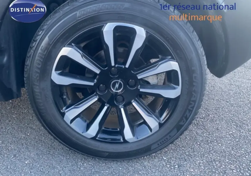 Gros plan sur la jante alliage 17 pouces noire et gris argenté de l'Opel Crossland gris foncé côté avant droit.