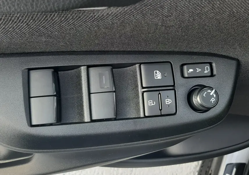 Panneau de commandes des vitres et rétroviseurs côté gauche intérieur d'une Toyota Yaris Cross 130H Design gris minéral 2025.