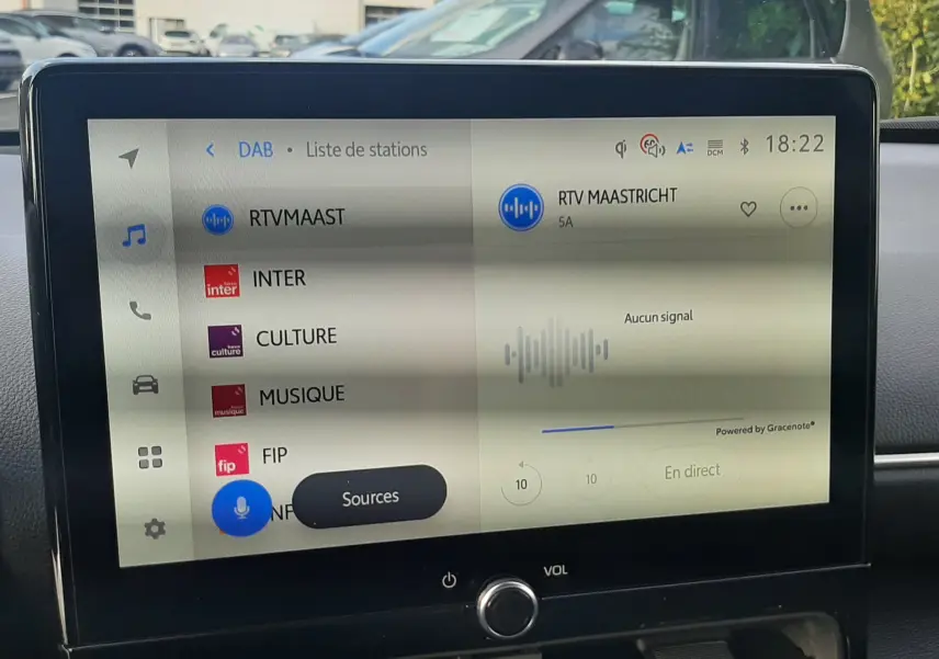 Écran tactile central de la Toyota Yaris Cross 130H Design affichant la liste des stations radio en intérieur noir.