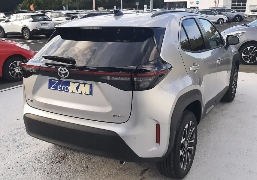 Toyota Yaris Cross 130H Design gris minéral vue 3/4 arrière droit avec toit noir et feux arrière LED distinctifs.