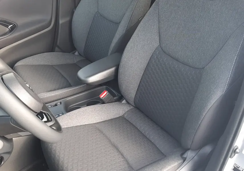 Vue intérieure rapprochée des sièges avant en tissu gris foncé de la Toyota Yaris Cross 130H Design 2025.