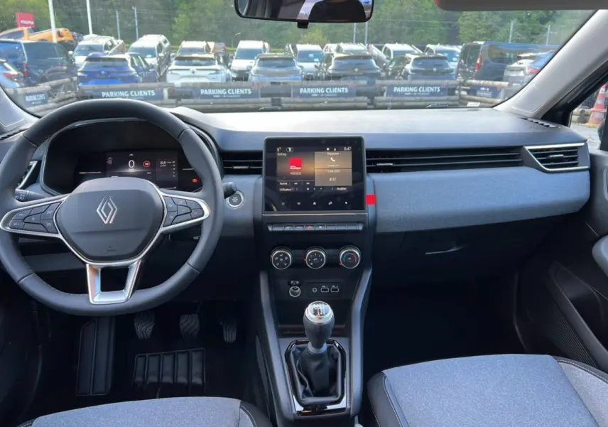 Intérieur de la Renault Clio DCI 100 Evolution 2025, vue tableau de bord avec volant, écran tactile et levier de vitesse manuel.