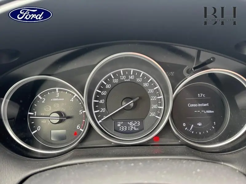 Tableau de bord du Mazda CX-5 2016 avec compte-tours, compteur de vitesse et écran digital affichant 133134 km.