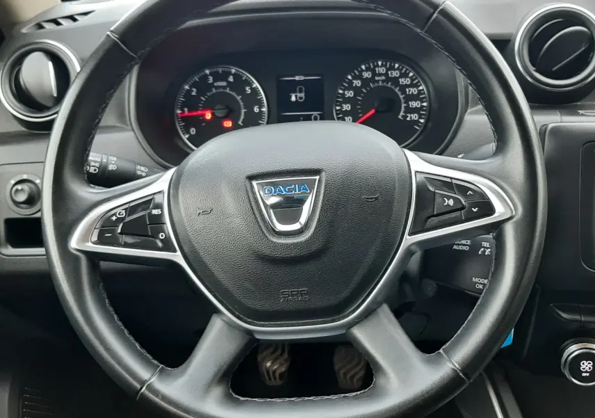 Vue centrée sur le volant noir du Dacia Duster 2019 avec tableau de bord et commandes visibles en arrière-plan.