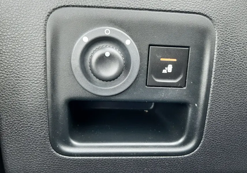 Gros plan sur les commandes de réglage des rétroviseurs intérieurs noirs du Dacia Duster gris Cassiopée, version 2019.