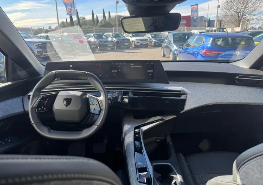 Vue intérieure du tableau de bord et volant noir du Peugeot 5008 Hybrid 145 e-DCS6 Allure 2025, avec cockpit numérique.