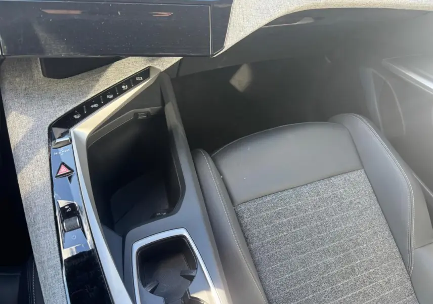 Vue plongeante sur la console centrale et siège avant gris tissu et cuir du Peugeot 5008 Hybrid 145 e-DCS6 Allure 2025.