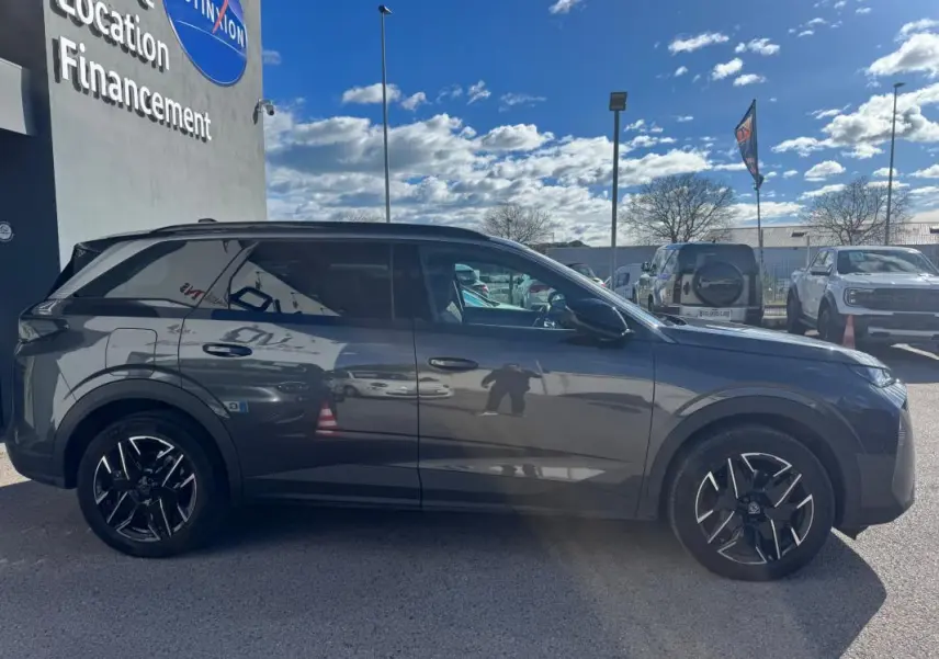 Peugeot 5008 gris vue de profil côté gauche, avec jantes alliage noires et vitres teintées.