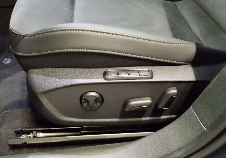 Gros plan sur les commandes électriques du siège conducteur en suédine noire et cuir beige du CUPRA Formentor 2026.