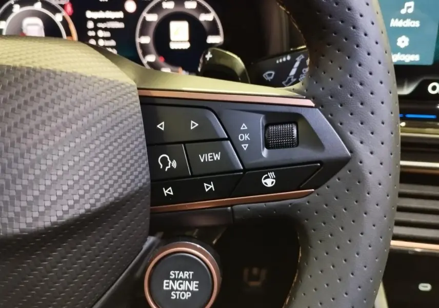 Gros plan sur le volant perforé noir avec commandes intégrées et bouton Start Engine Stop cuivré du CUPRA Formentor Magnetic Tech.
