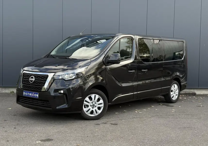 Nissan Primastar noir métal vu en 3/4 avant droit, avec vitres latérales teintées et jantes alliage.