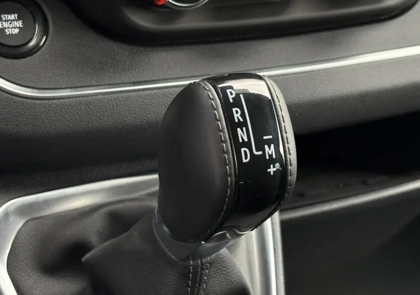 Gros plan sur le levier de vitesses automatique noir du Nissan Primastar 2025, avec marquages PRND et mode manuel.