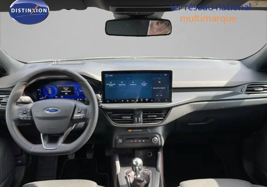 Vue intérieure avant de la Ford Focus SW 2023 gris lunaire, tableau de bord moderne avec écran tactile et volant multifonction.