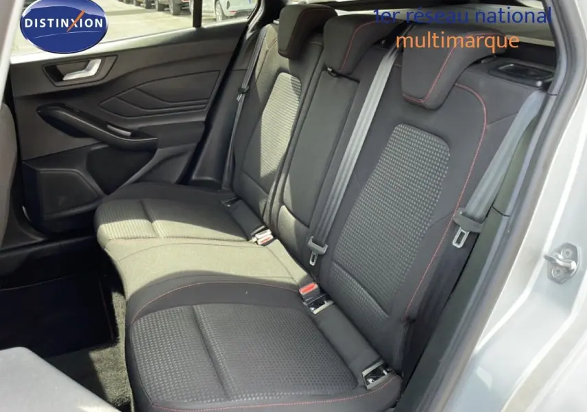 Vue intérieure côté droit des sièges arrière noirs avec surpiqûres rouges d'une Ford Focus SW 2023 gris lunaire métal.