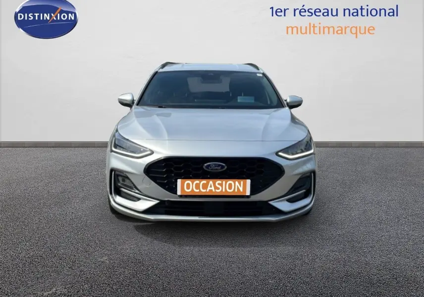 Vue avant d'une Ford Focus SW gris lunaire métal avec calandre noire et phares LED allumés.