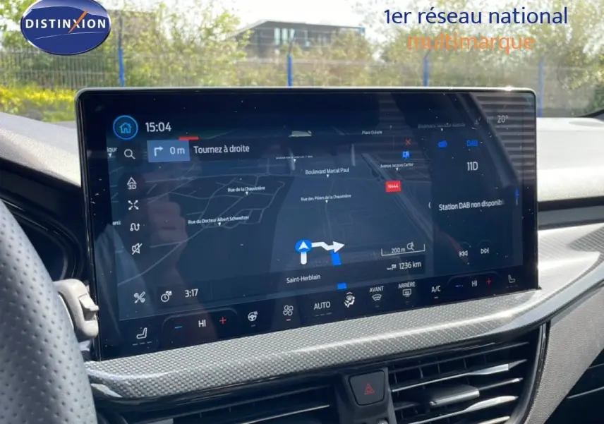 Vue intérieure du tableau de bord de la Ford Focus SW 2023, écran tactile affichant la navigation et la climatisation.