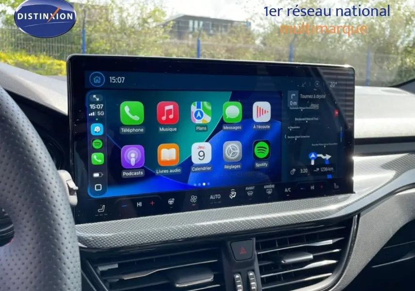 Vue intérieure centrée sur l'écran tactile du tableau de bord de la Ford Focus SW gris lunaire 2023, affichant les applications connectées.