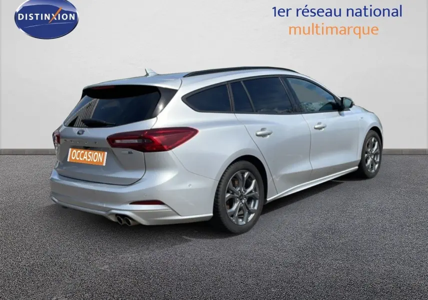 Vue 3/4 arrière droite d'une Ford Focus SW gris lunaire métal avec jantes alliage et double sortie d'échappement.