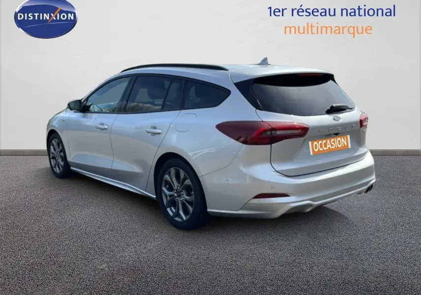 Ford Focus SW gris lunaire métal vue 3/4 arrière droit, carrosserie lisse et feux arrière allongés.