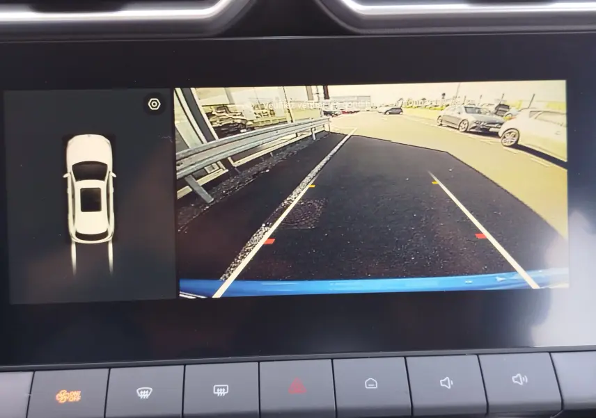 Vue écran caméra de recul du MG ZS Cosmo Blue, affichant l'arrière et les lignes de guidage sur route asphaltée.