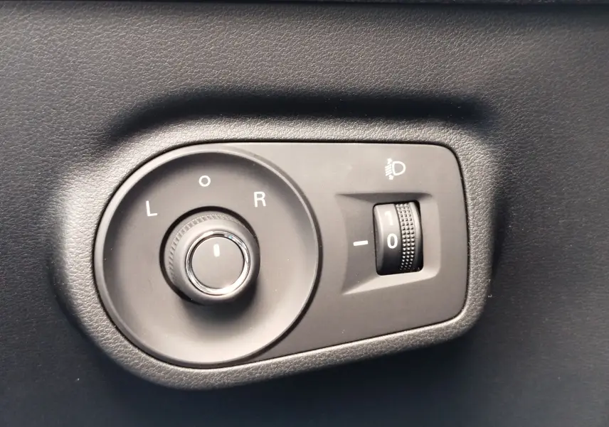 Gros plan sur la commande de réglage des rétroviseurs et de l'inclinaison des phares du MG ZS Cosmo Blue 2026.